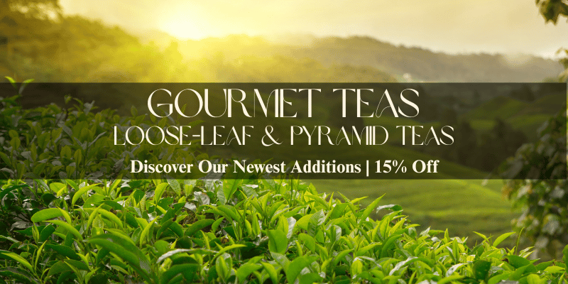 A promotional banner for Gourmet Loose-Leaf Tea featuring a scenic background of a lush green tea plantation with misty mountains and a warm golden sunrise. A dark translucent horizontal banner overlays the center with the text 'GOURMET LOOSE-LEAF TEA' and 'Discover Our Newest Additions | 15% Off'.
